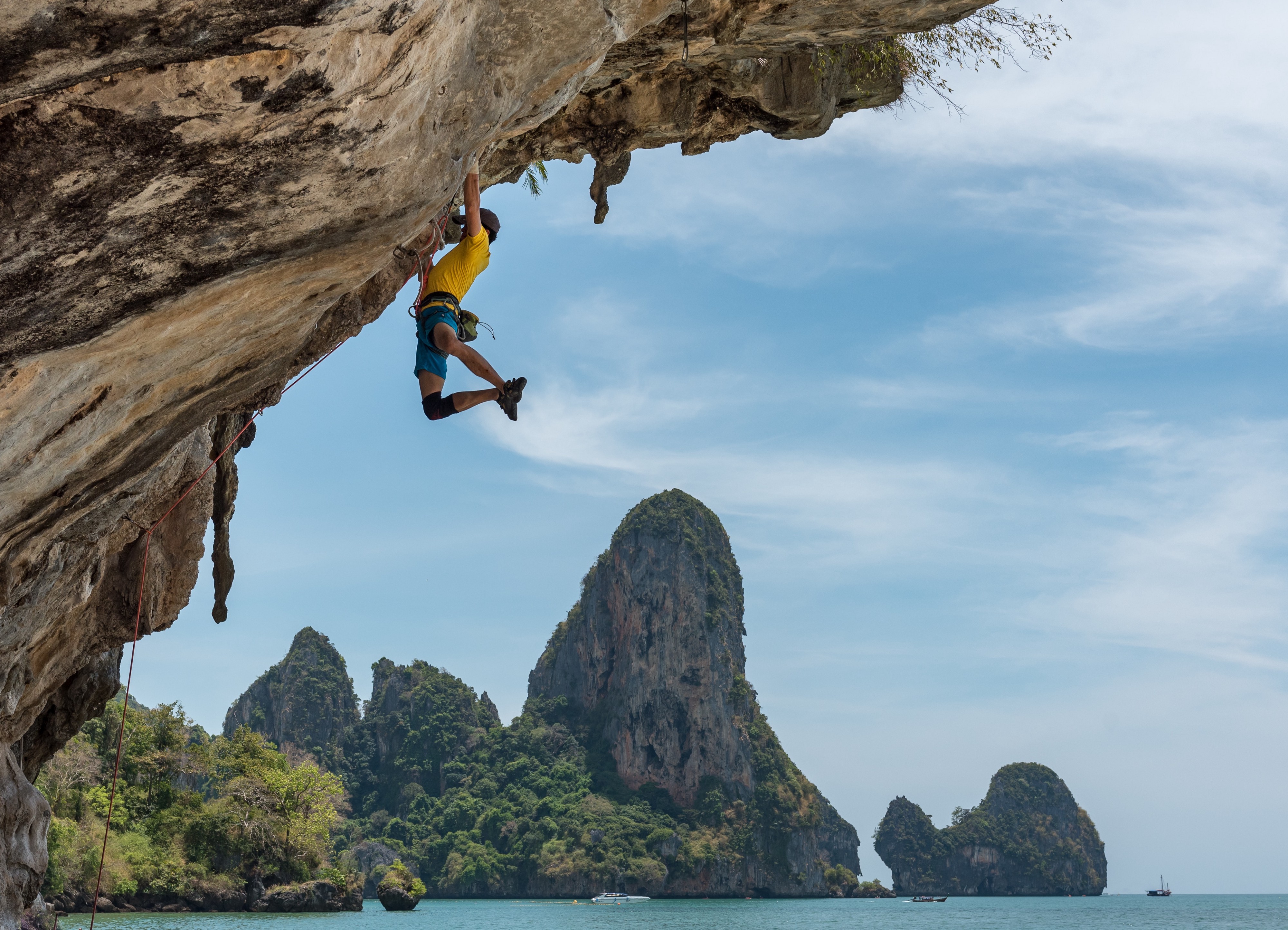 Illustrative: a man hanging from a cliff